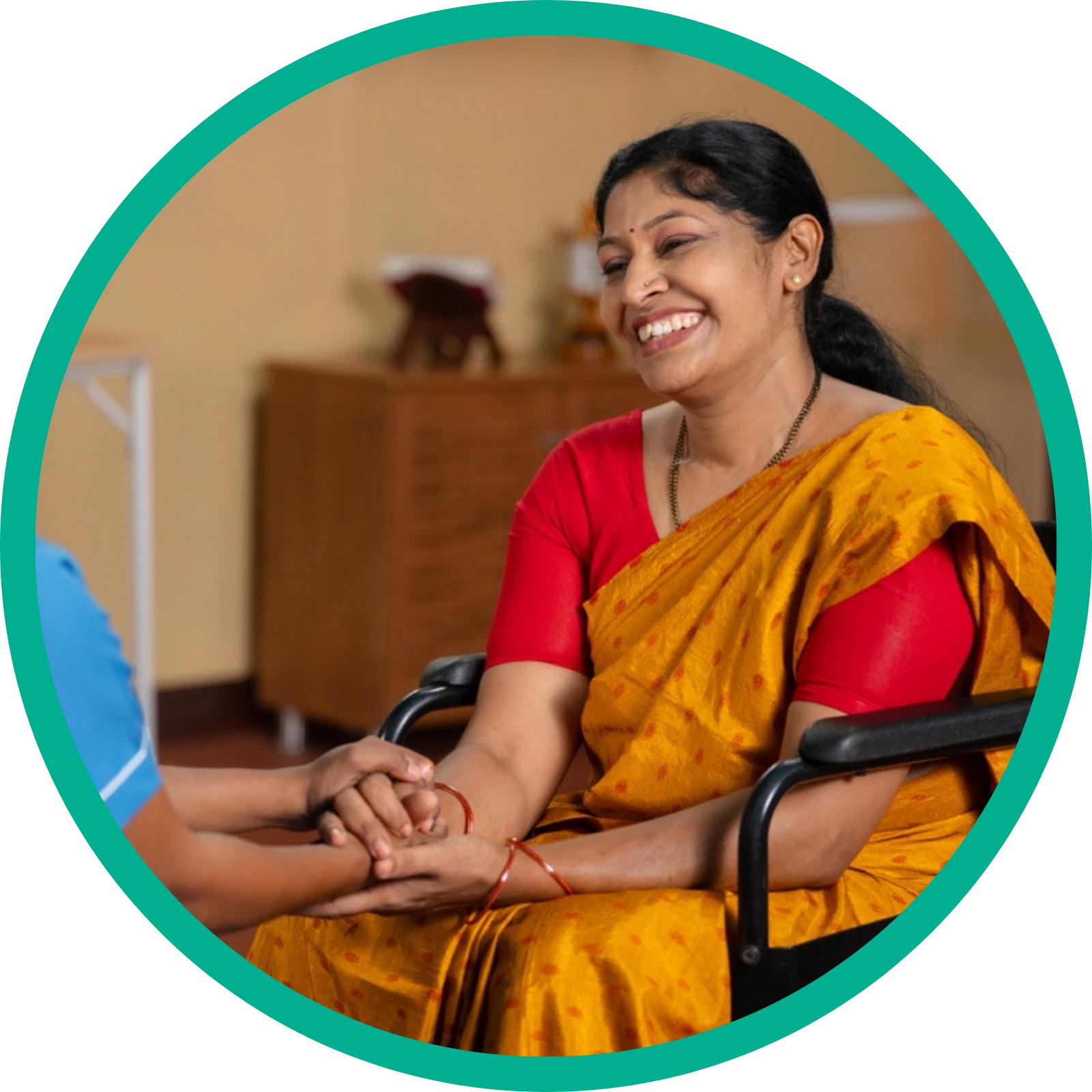 Nurse comforting a disabled Indian women in traditional dress