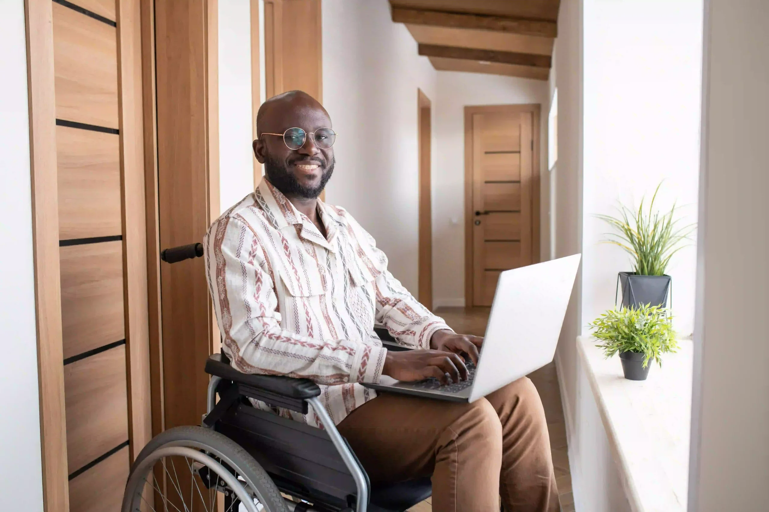 Disabled men on wheelchair working on laptop and smiling