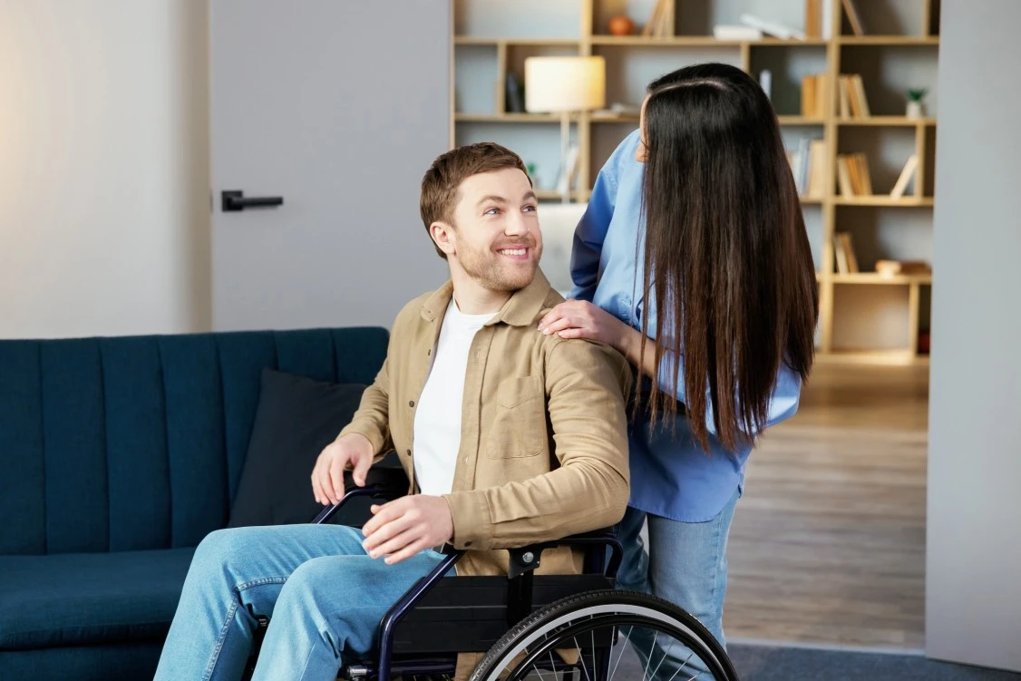 Nurse looking at a disabled men on wheelchair